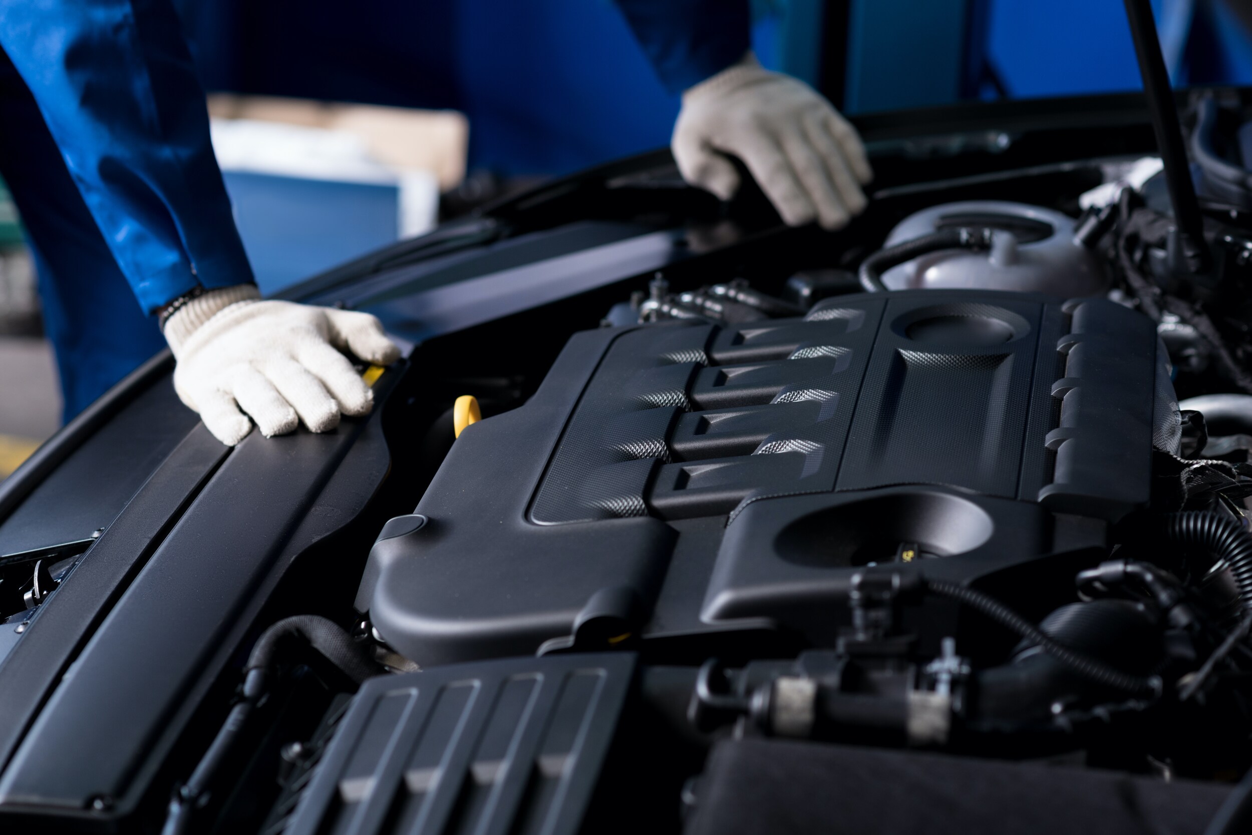 Service technician examining engine of vehicle