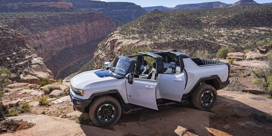 Side view of the 2023 Hummer EV Pickup with rocky terrain in the background