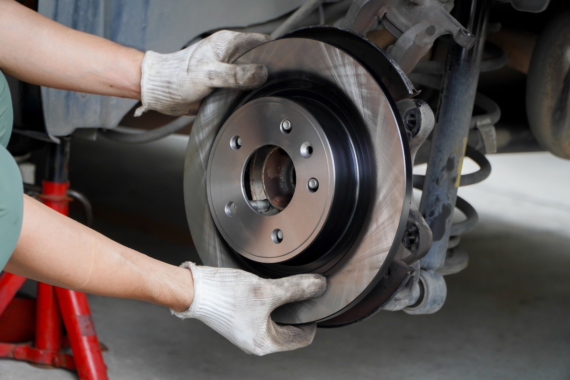 A service technician holding the brake discs of a vehicle