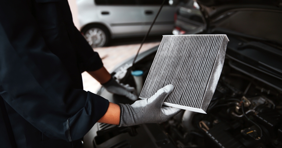 Technician replacing a vehicle's air filter