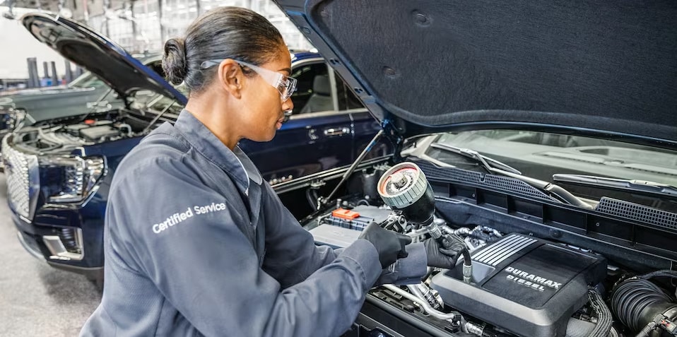 A GMC technician performing service on a vehicle
