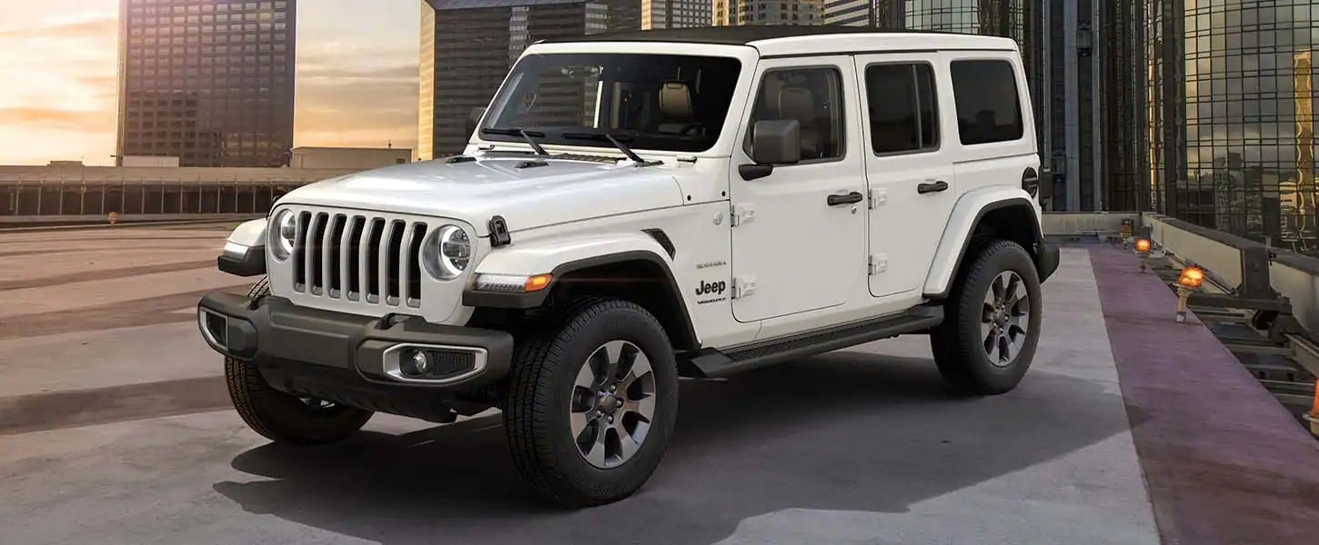  White New Jeep Wrangler parked on top of a parking garage in the city