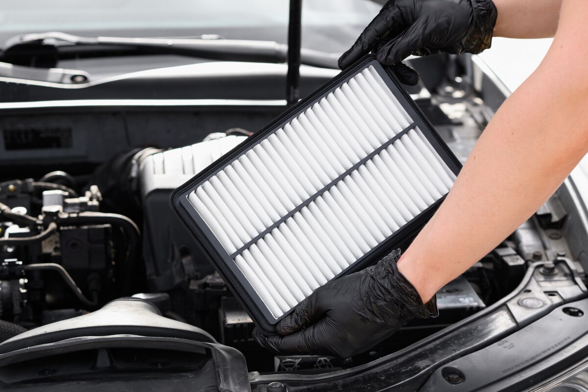A mechanic replacing a vehicle's air filter