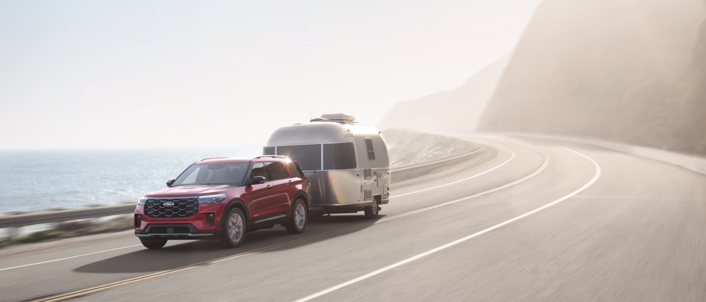 2025 Ford Explorer exterior towing camper on curved road