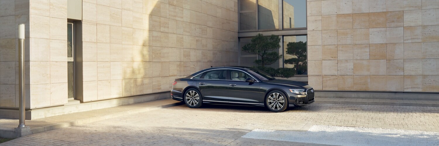 Audi A8 parked in front of a industrial building