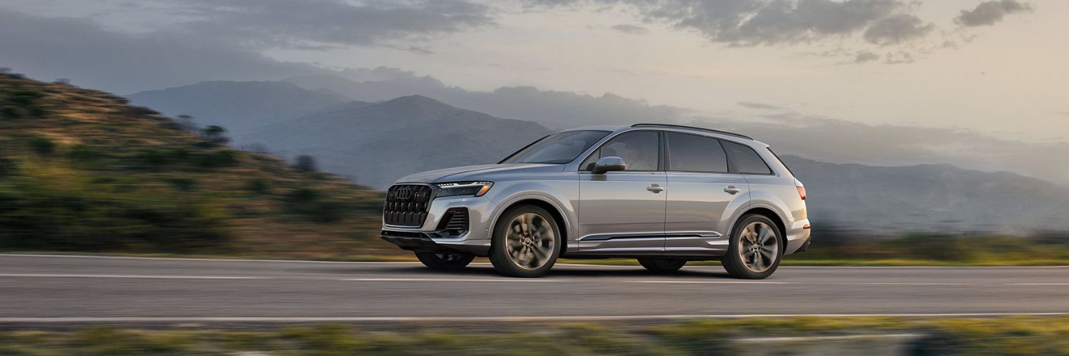 Silver Q7 driving down a scenic highway