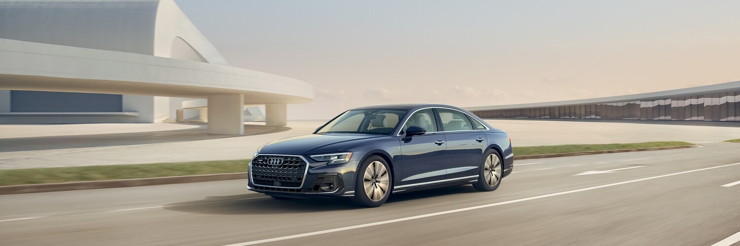 Audi A8 parked in front of a modern house