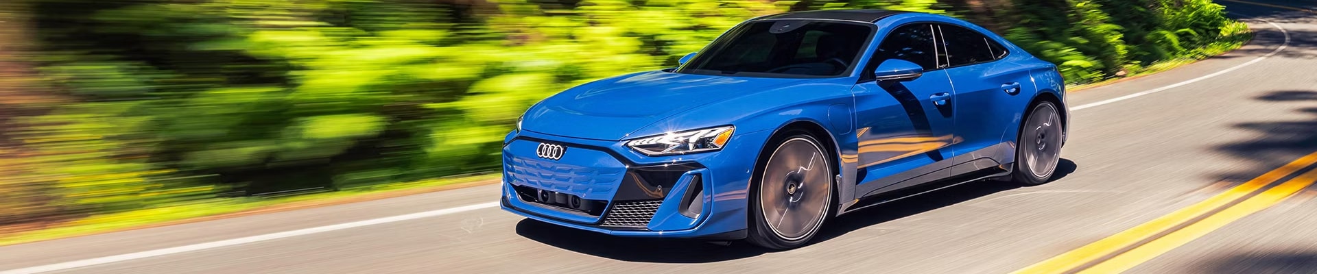 Blue Audi driving on road