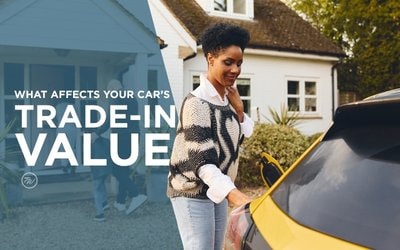 Woman standing next to her car learning what affects trade-in value in Indiana — Tom Wood Automotive Group