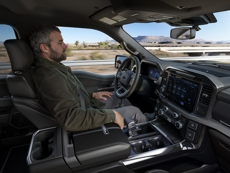 2025 Super Duty® hitched to a horse trailer with a horse and person at the back.