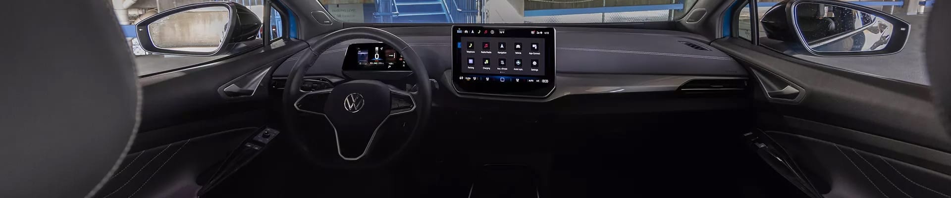 Interior view of a Volkswagen vehicle showing the steering wheel, digital instrument cluster, dashboard, and center touchscreen.