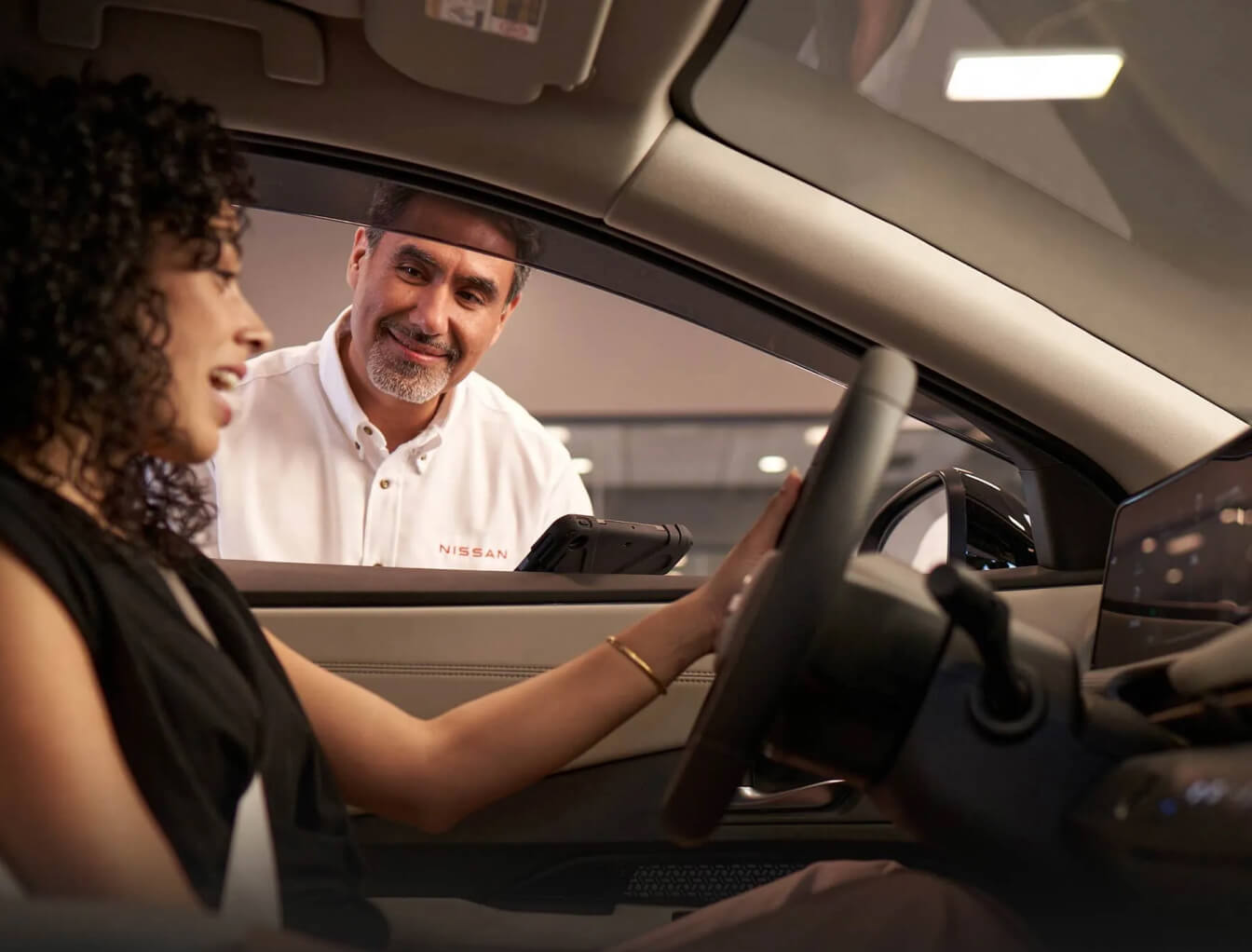 Business professional in white shirt speaking with client inside car interior during automotive consultation
