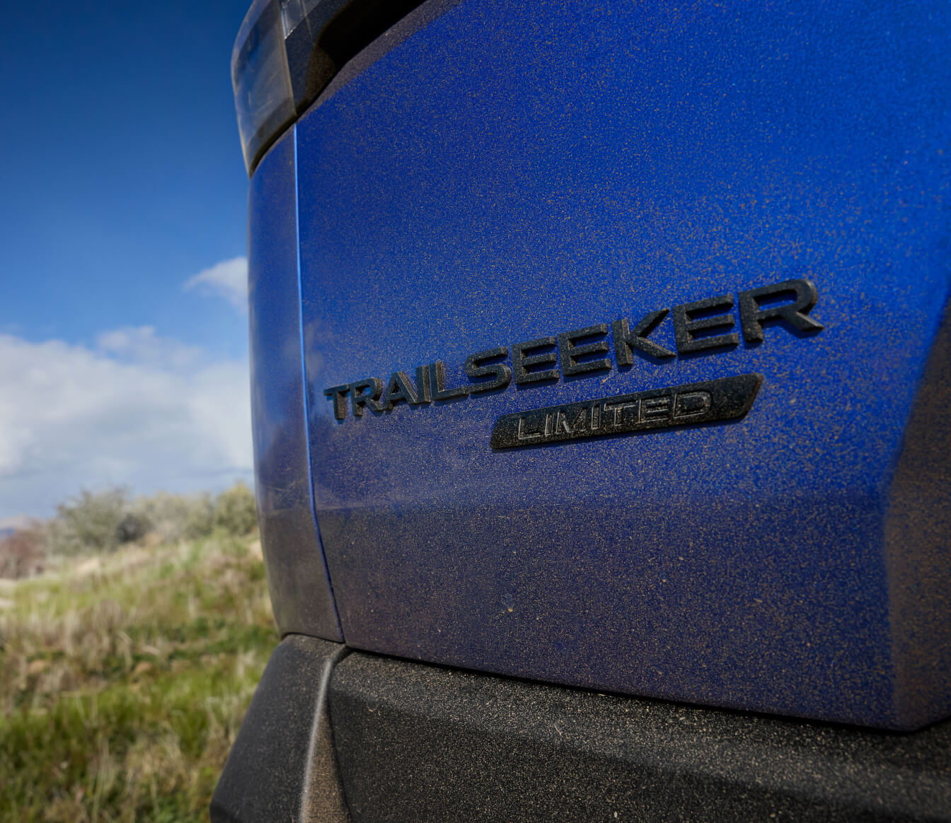 Close-up view of the Trailseeker Limited badge on a dusty blue Subaru body.