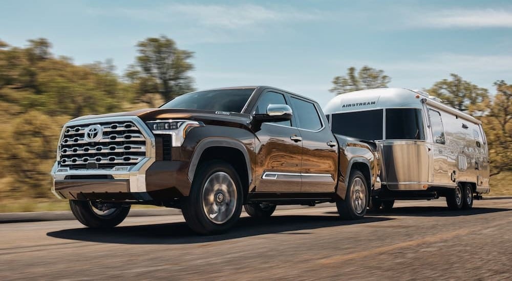 A brown 2025 Toyota Tundra towing a trailer to a Toyota dealer near Russelville.