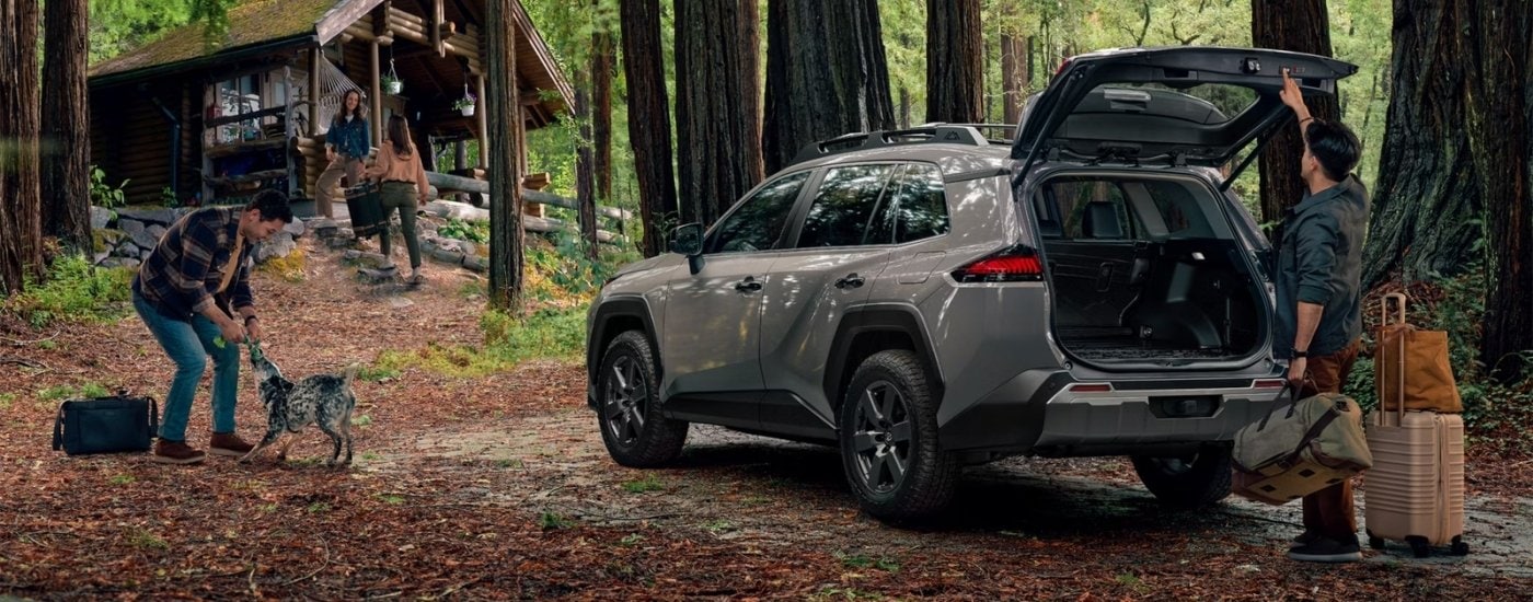 A grey 2026 Toyota RAV4 parked near a cabin.