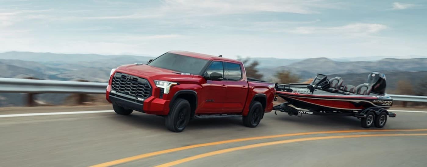 A red 2024 Toyota Tundra towing a boat.