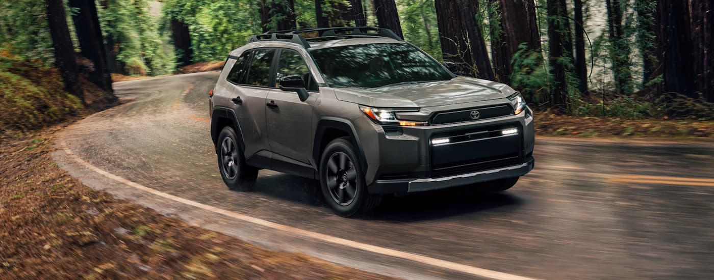 Grey 2026 Toyota RAV4 for sale near Madisonville driving through a forest.