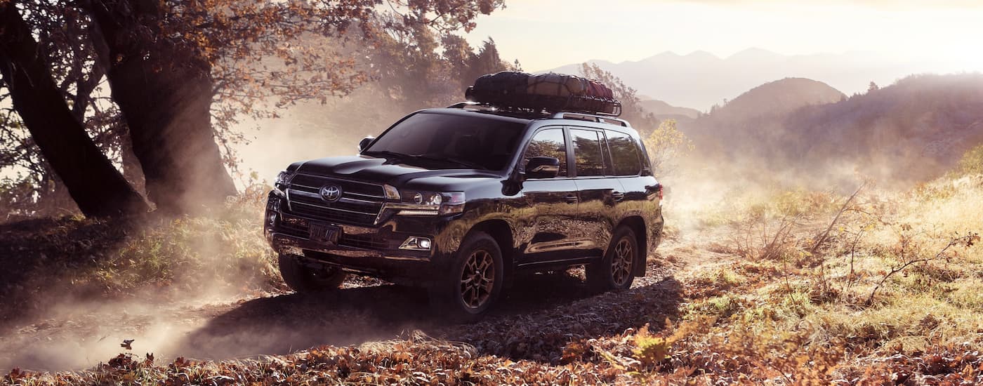 A black 2020 Toyota Land Cruiser is shown driving off-road.
