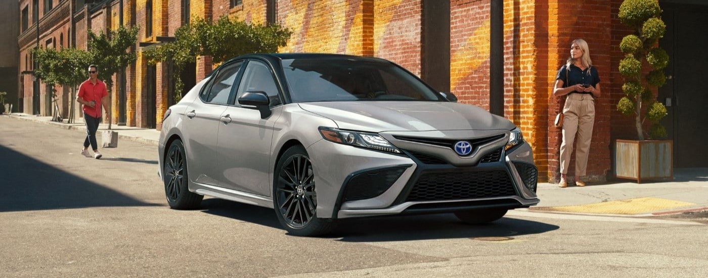 A silver 2023 Toyota Camry XSE Hybrid is shown stopped at an intersection.