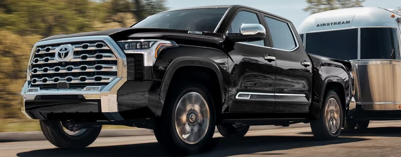 Black 2026 Toyota Tundra towing a silver camper trailer
