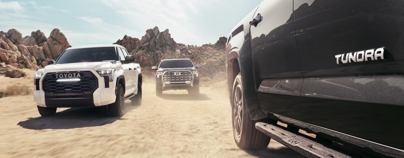 Two 2025 Toyota Tundras driving on sand