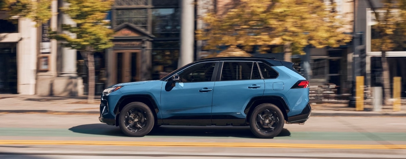 A blue 2024 Toyota RAV4 from the side.