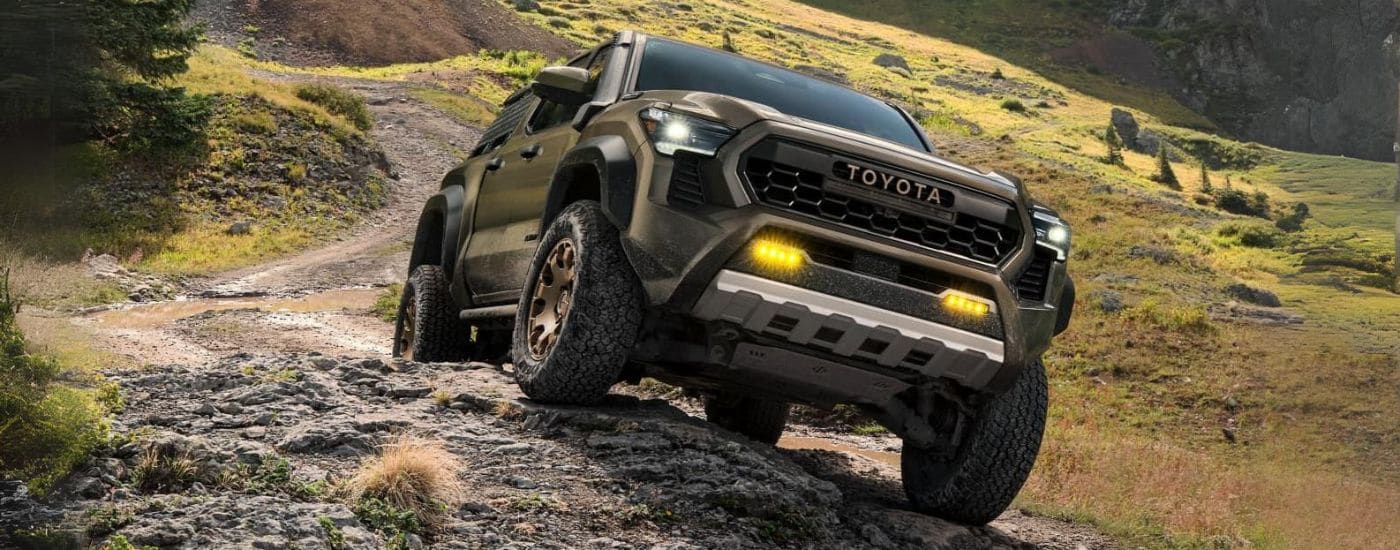 A green 2024 Toyota Tacoma Trailhunter is shown off-roading after leaving a Toyota dealer in Hopkinsville.