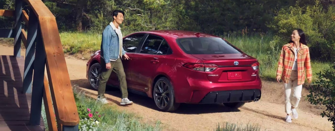 Red 2026 Toyota Corolla from the rear with a couple getting out of it