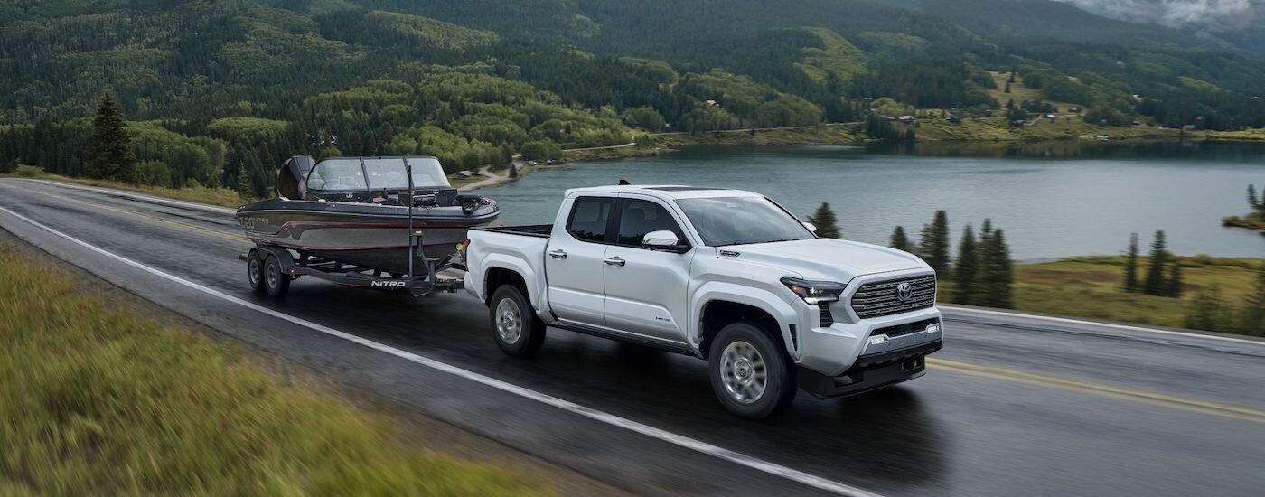 A white 2025 Toyota Tacoma for sale near Russelville towing a boat.