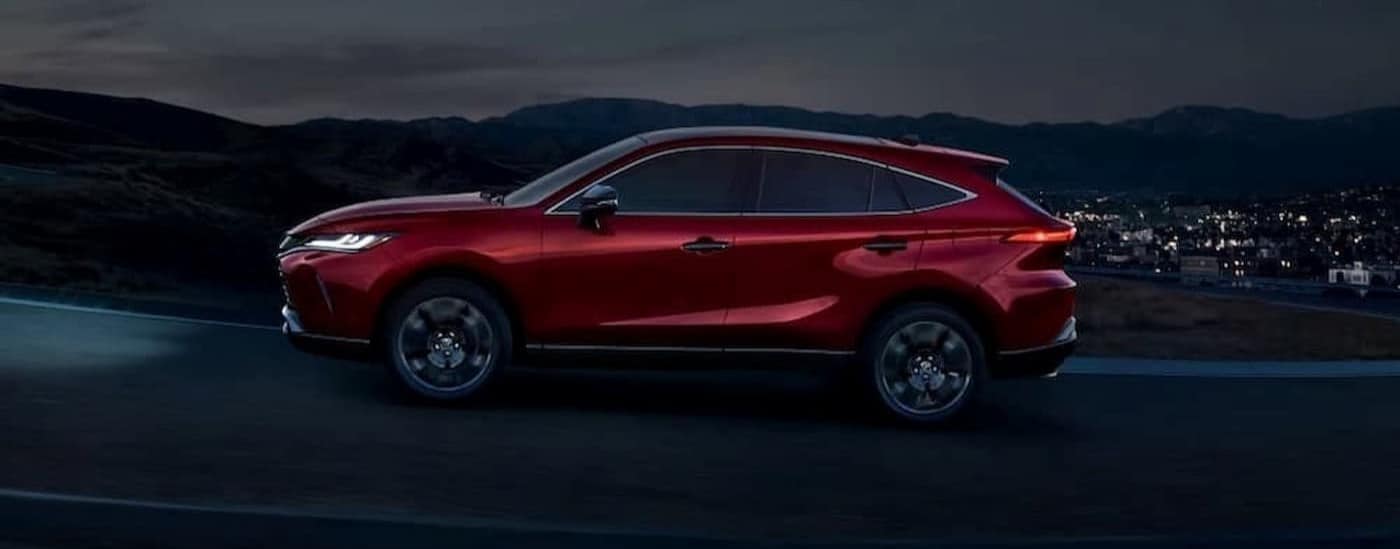 A red 2023 Toyota Venza driving at night.