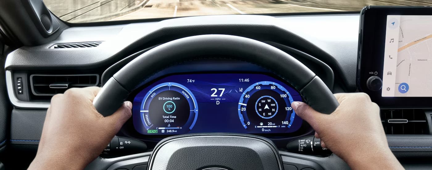 Person putting their hands on a steering wheel of a 2025 Toyota RAV4