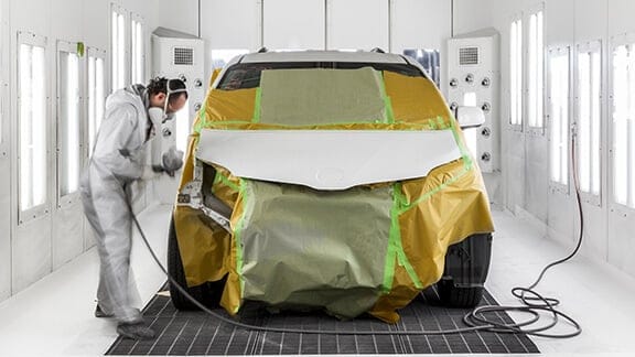Toyota Collision Center Technician buffing out vehicle body panel.