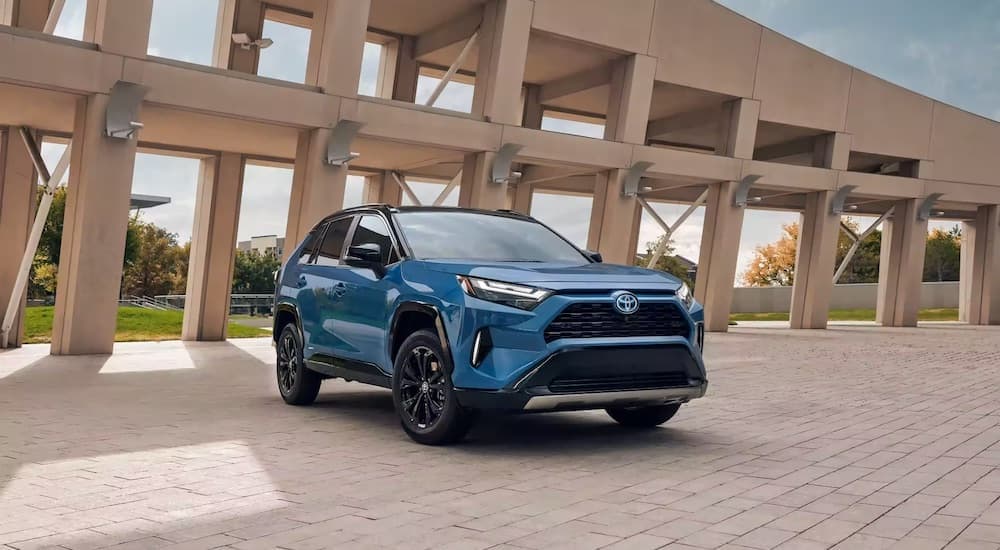A blue 2023 Toyota RAV4 XSE Hybrid is shown from the front at an angle after leaving a dealer that has a Toyota RAV4 Hybrid for sale.