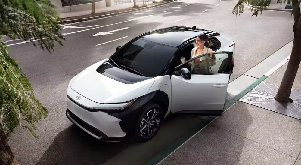 A white 2023 Toyota BZ4X is shown parked near a curb.