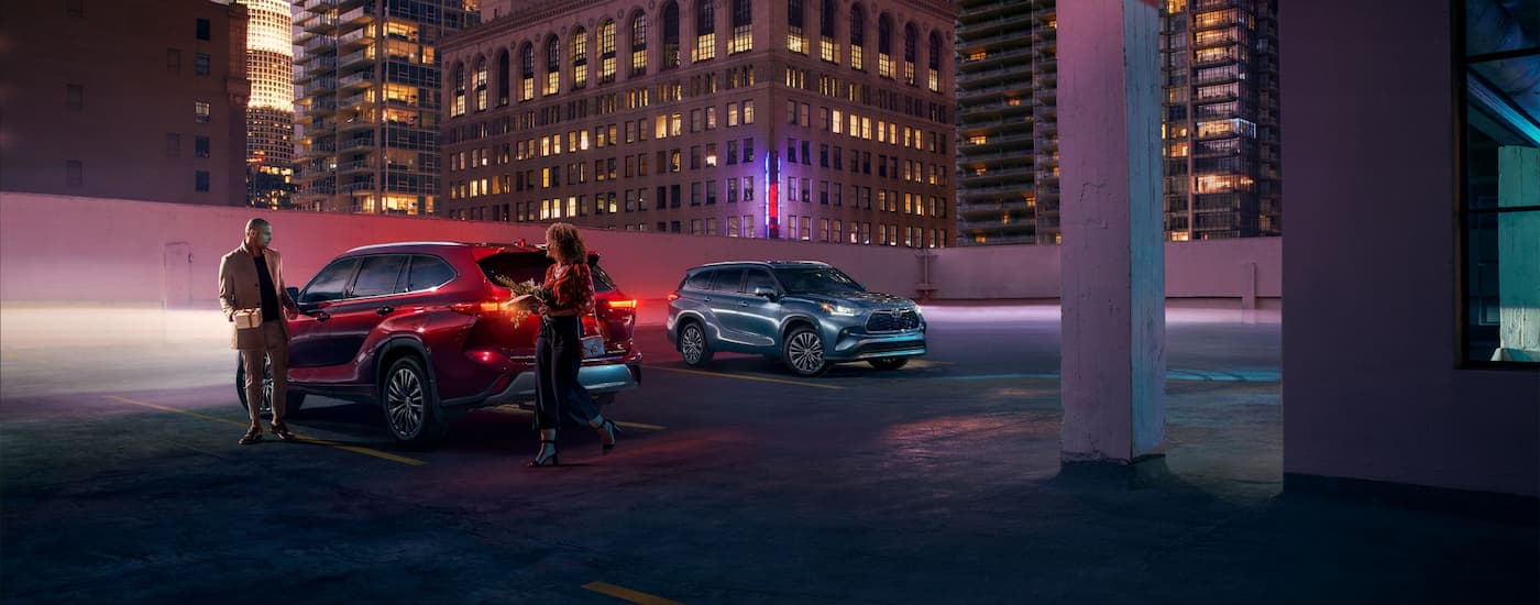 A red and a silver 2024 Toyota Highlander are shown parked on a rooftop parking area after leaving a Toyota dealer near the Bronx.