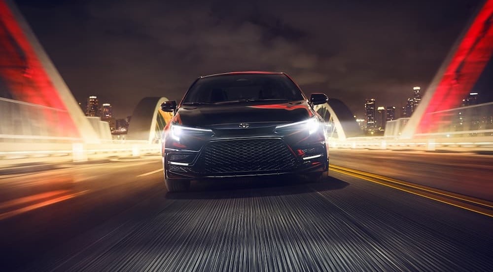 A black 2024 Toyota Corolla Sedan is shown driving to a Toyota dealer near the Bronx.