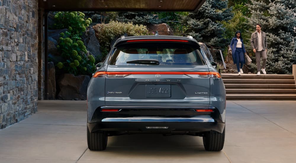 A blue-grey 2025 Toyota Crown Signia is shown from the rear parked in a driveway.