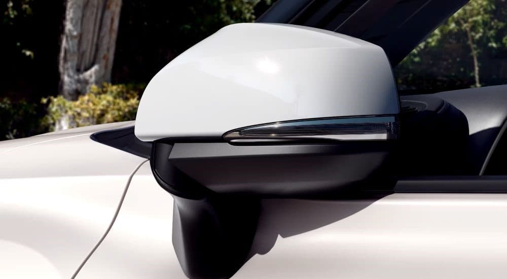 A close up of the side mirror on a 2023 Toyota Highlander Platinum Hybrid for sale is shown.