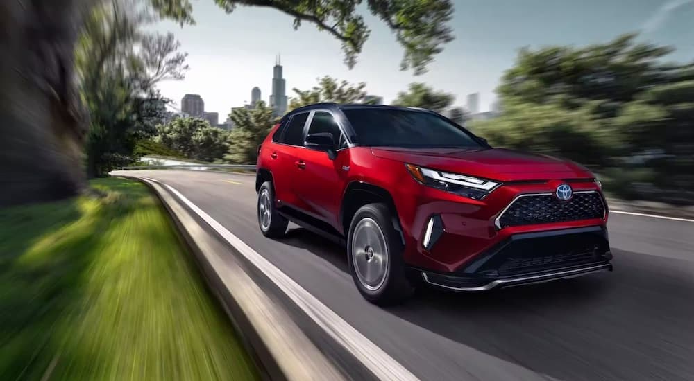 A red 2023 Toyota RAV4 is shown from the front at an angle after leaving a used Toyota dealership.
