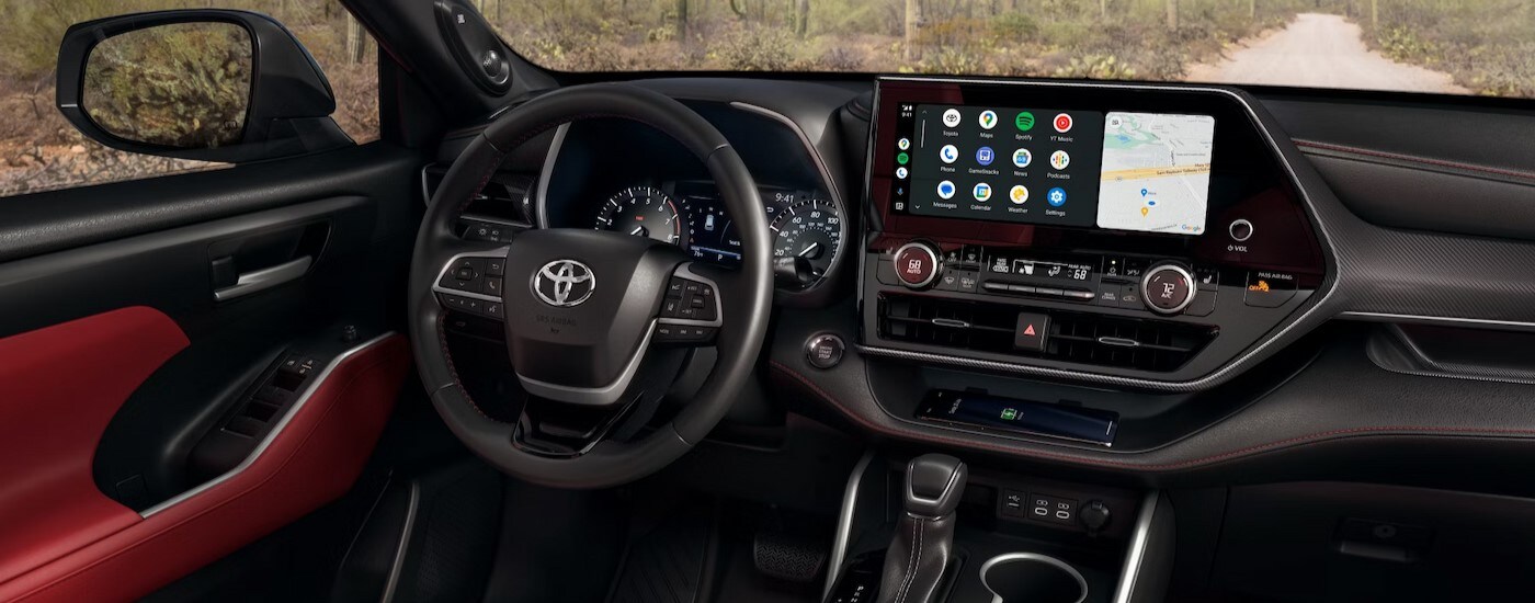 The black and red interior and dash in a 2024 Toyota Highlander Hybrid is shown.