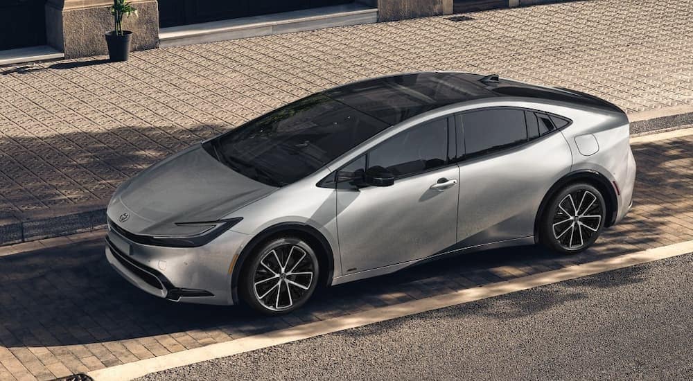 A silver 2024 Toyota Prius is shown parked at a Toyota dealer near Queens.