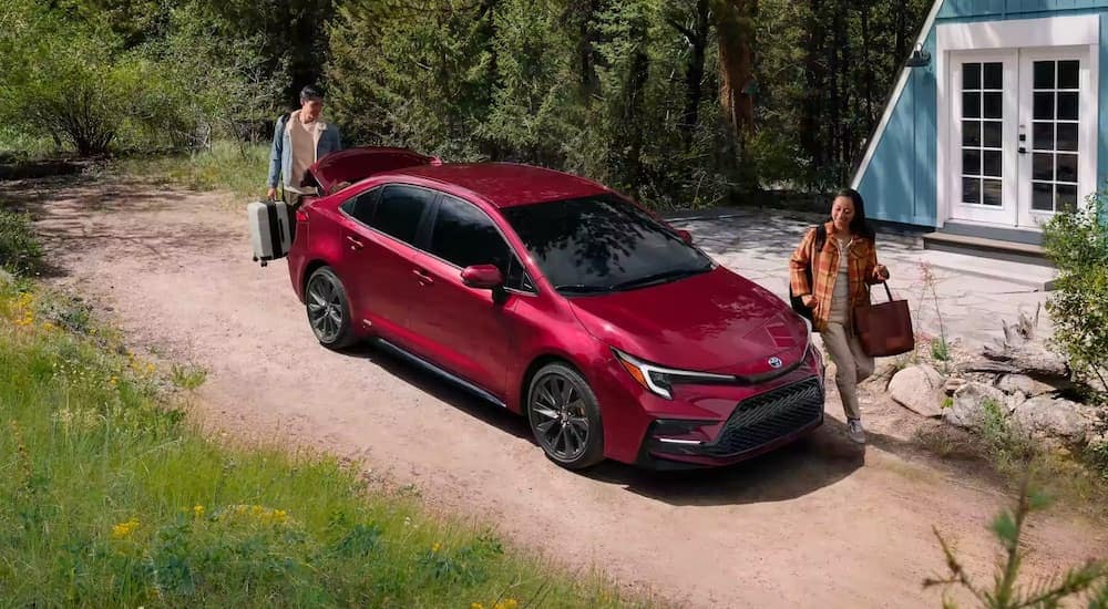 a red 2024 Toyota Corolla Hybrid is shown from the front at an angle after leaving a Toyota dealer near Brooklyn.