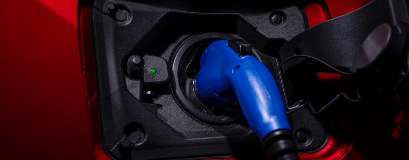 The charging port on a red 2024 Toyota RAV4 Prime.
