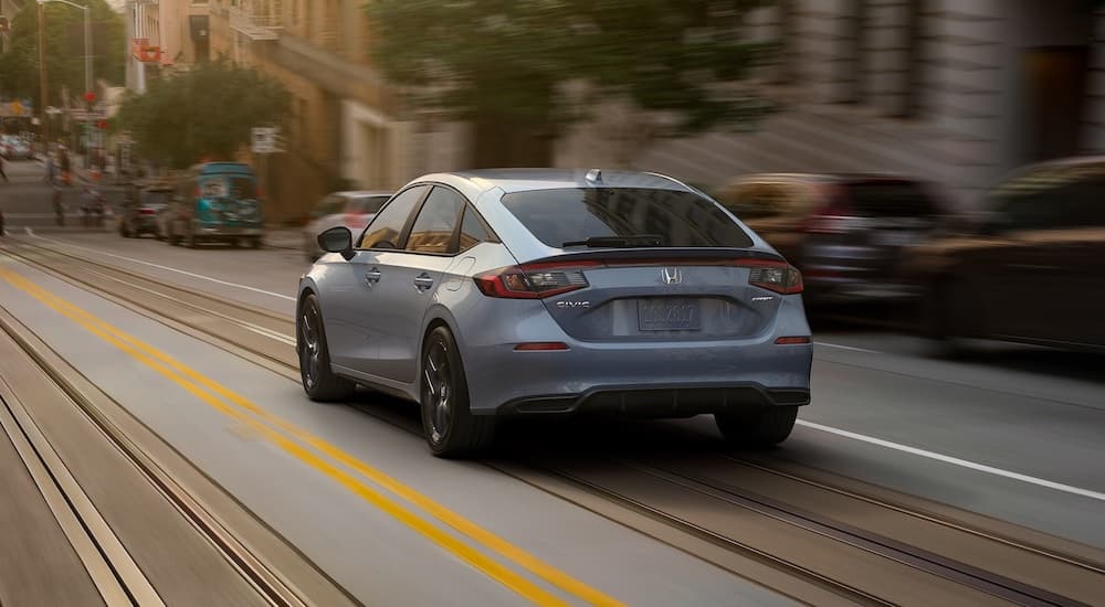 A grey 2022 Honda Civic Hatch is shown from the rear on a city street.