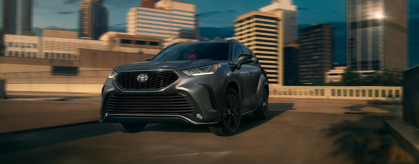 A grey 2024 Toyota Highlander XSE driving through a city.