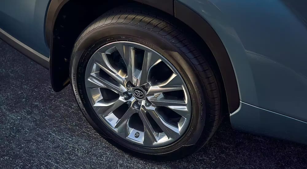 A close up of the silver rim on a grey 2023 Toyota Highlander for sale is shown.