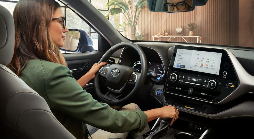 A woman is shown in the the driver's seat of a 2023 Toyota Highlander after visiting a Toyota Dealer in New York City.