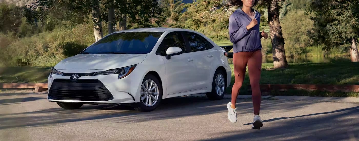 A white 2023 Toyota Corolla is shown in a parking lot after leaving a Toyota dealer.