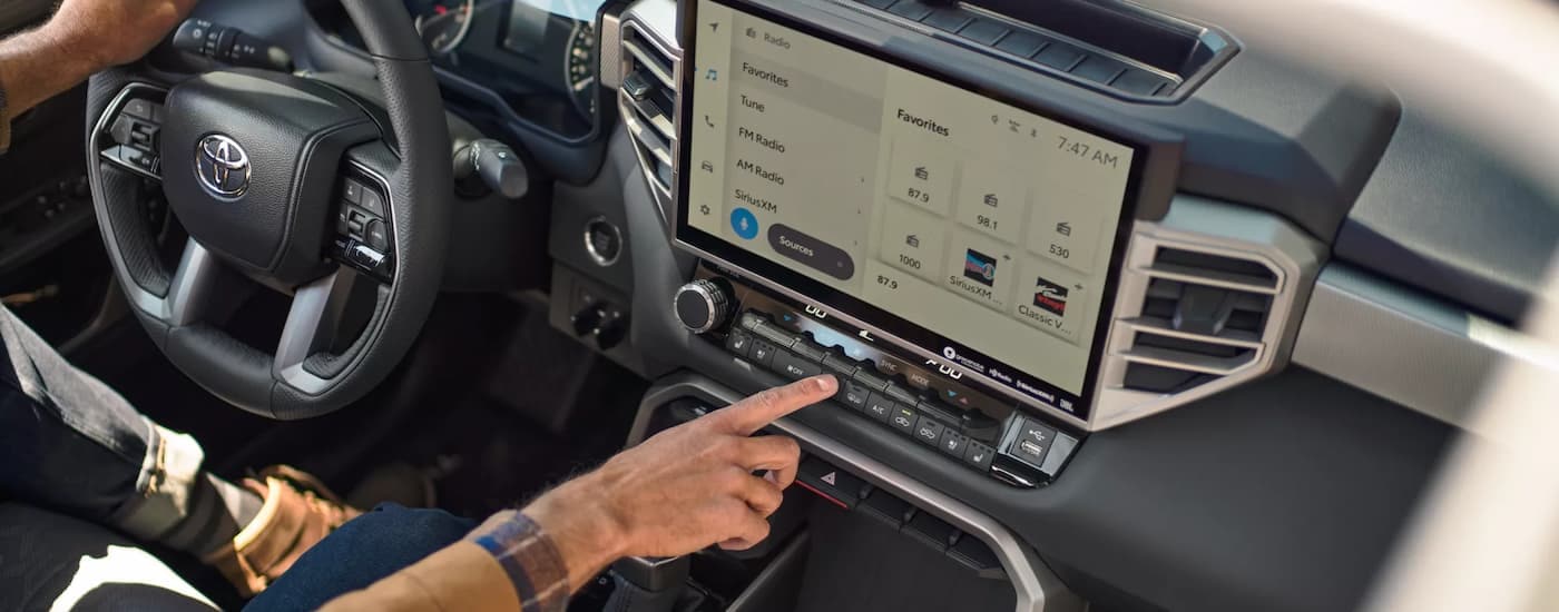 A person is shown using the infotainment screen in a 2022 Toyota Tundra.