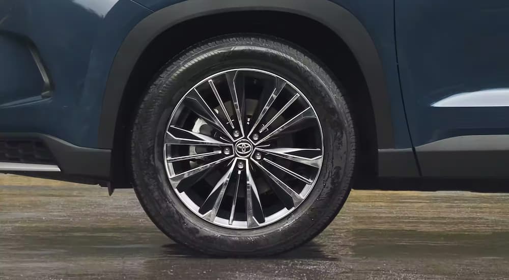 A close up of the rim on a blue 2024 Toyota Grand Highlander for sale is shown.